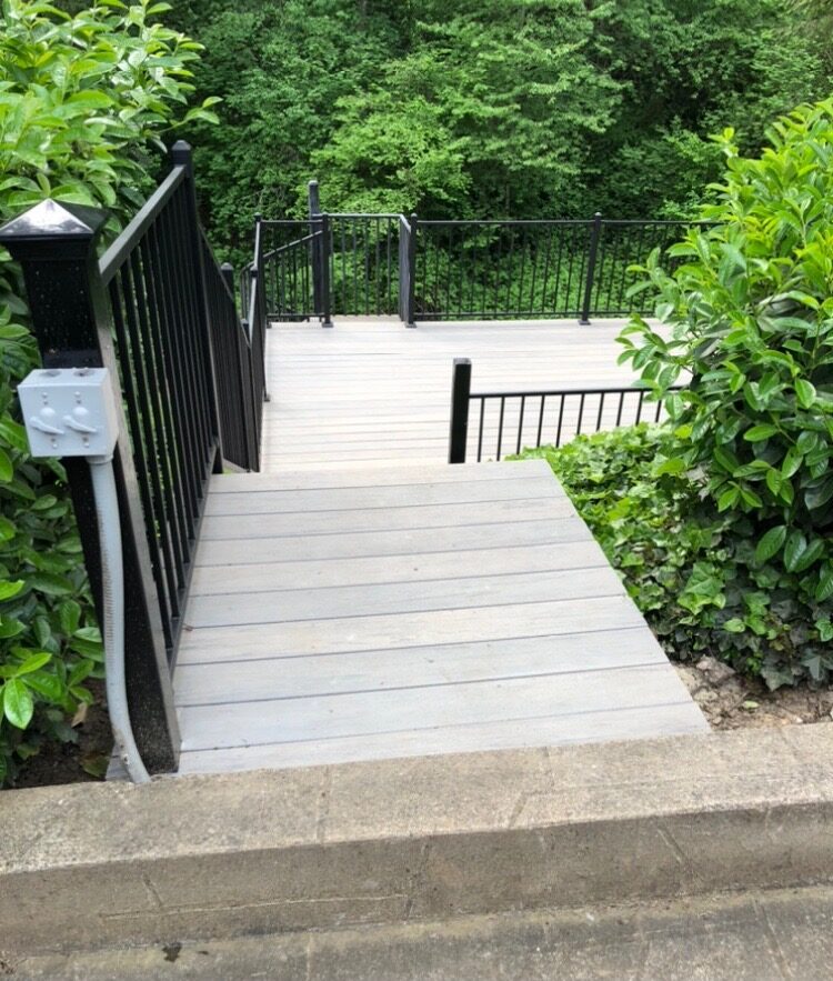 Rebuilt deck stairs with light composite treads and black metal railing