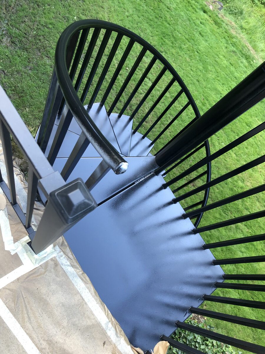 Overhead view of a curved deck with black metal railing over a lawn